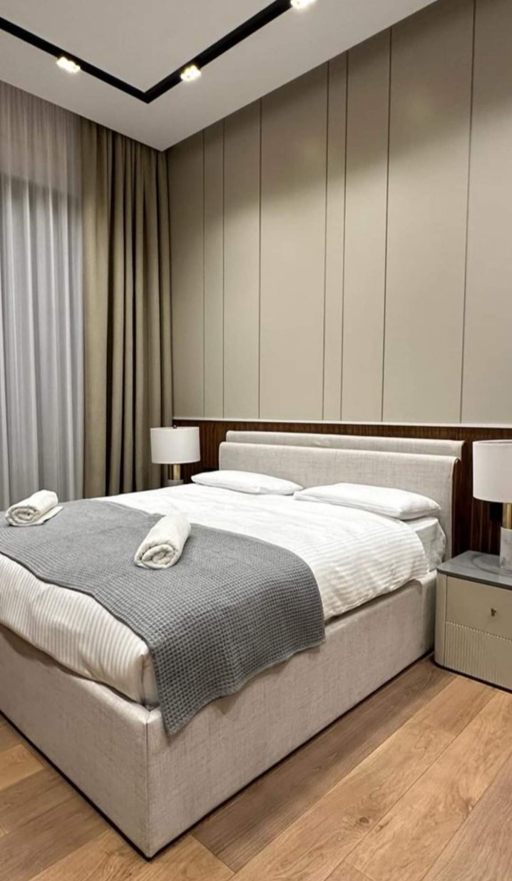 Wirth Bed — bež tapacirano uzglavlje, hotelski ambijent